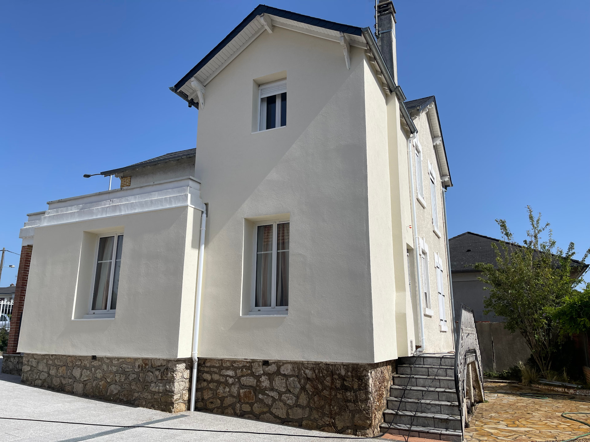 Maison rénovée avec ravalement clair et soubassement en pierre