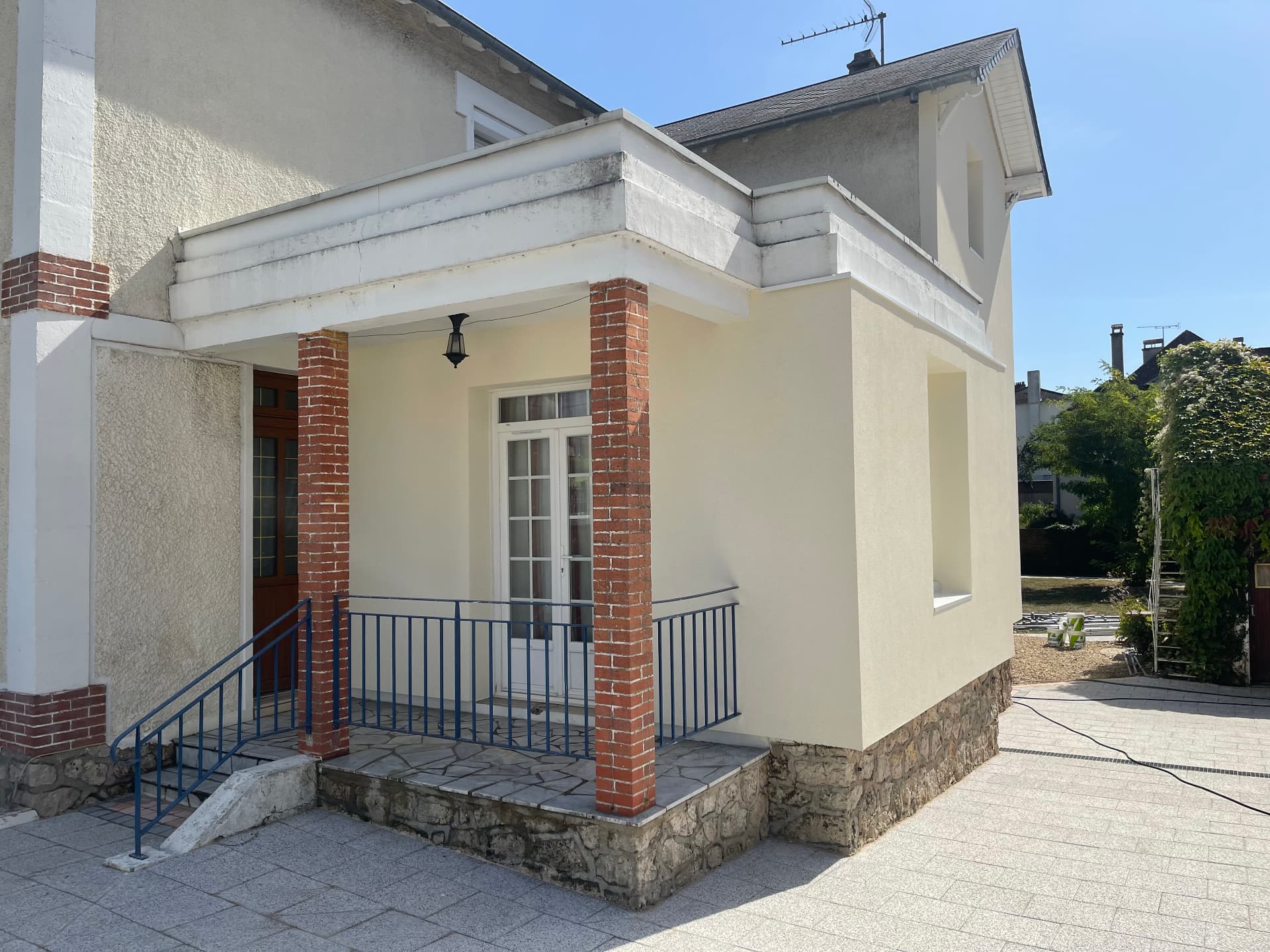 Perron et façade rénovés, enduit crème et briques