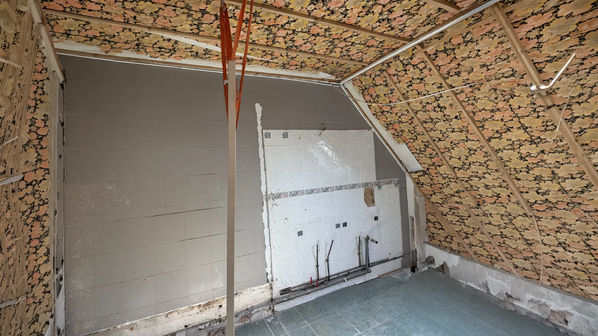Salle de bains à nu avant travaux, ancien papier peint et faïence